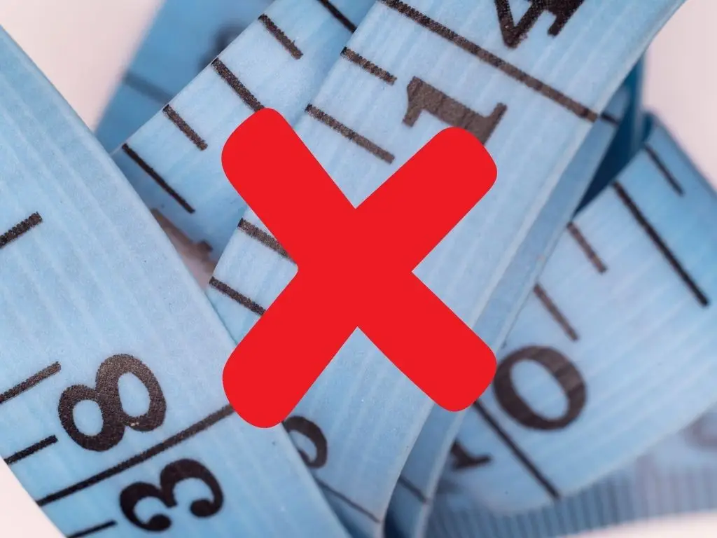 Blue measuring tape with a red X over it, symbolizing that bra fittings at Althea’s in Milwaukee do not use a tape measure.